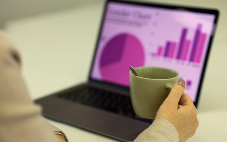 Portátil con gráficos y una taza