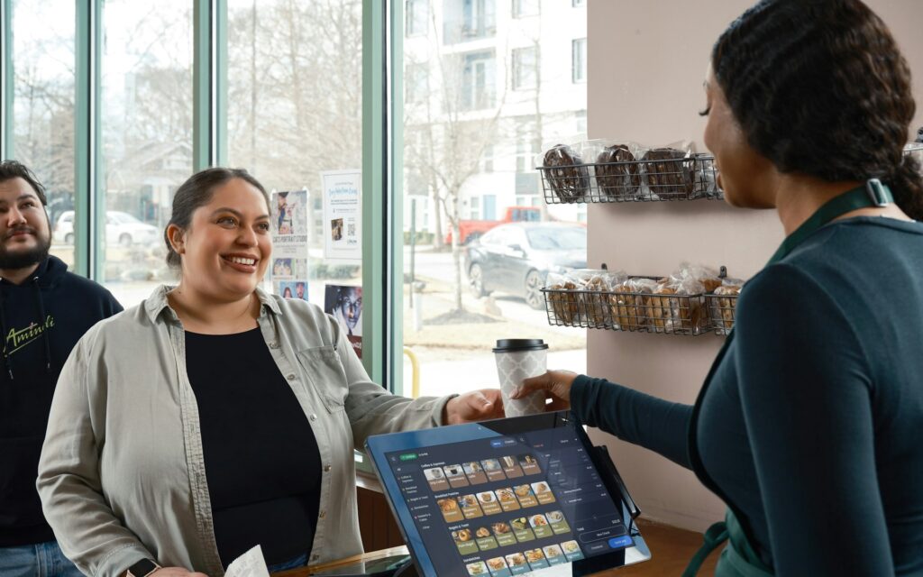Clienta sonriendo en el mostrador de una cafetería