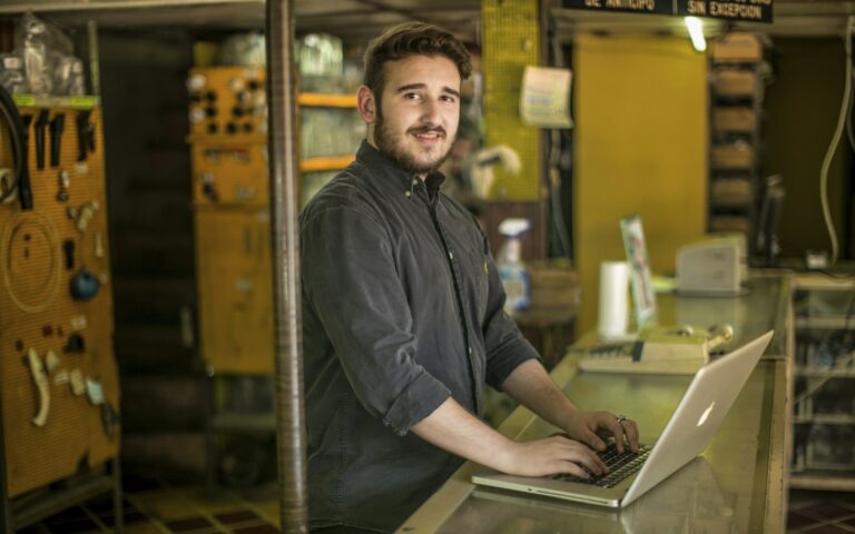 Dueño de un comercio con el portátil en el mostrador