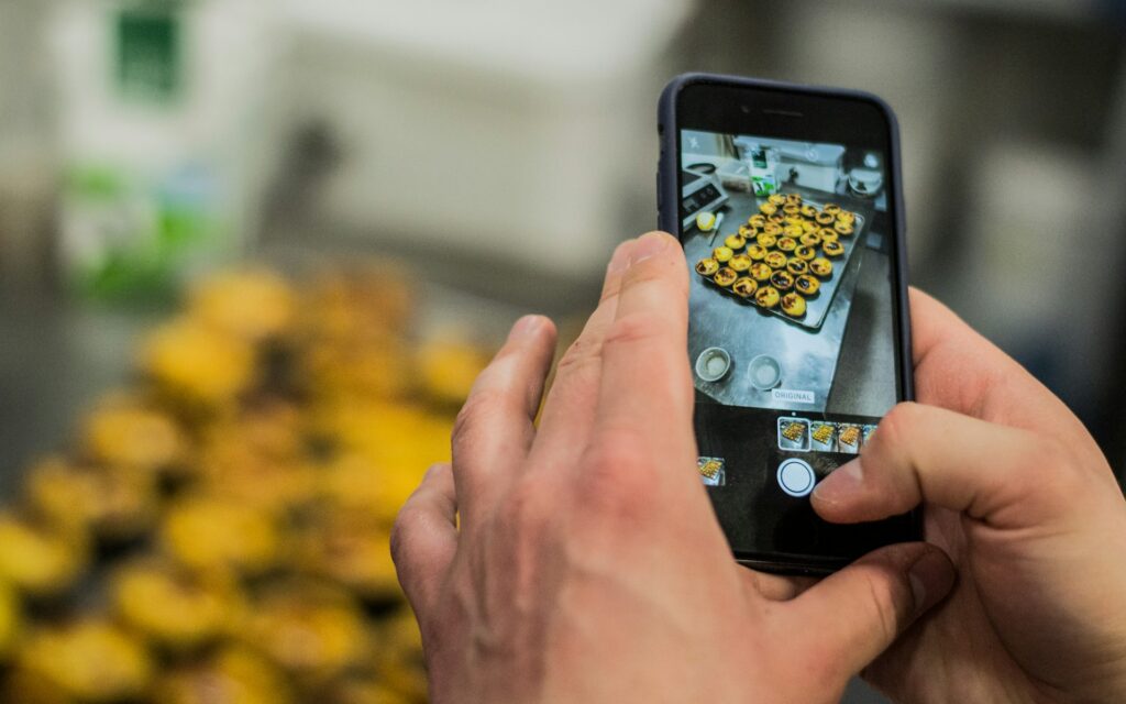 Manos fotografiando pasteles con el móvil